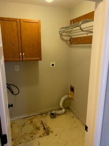 Laundry room with the washer and dryer removed. You can see the disgusting linoleum flooring beneath. 