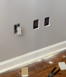 Here's what my wall looks like with the new outlet box holes cut out of my drywall so that I can add them in.
