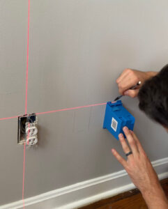 Tracing out the outlet box on the drywall.