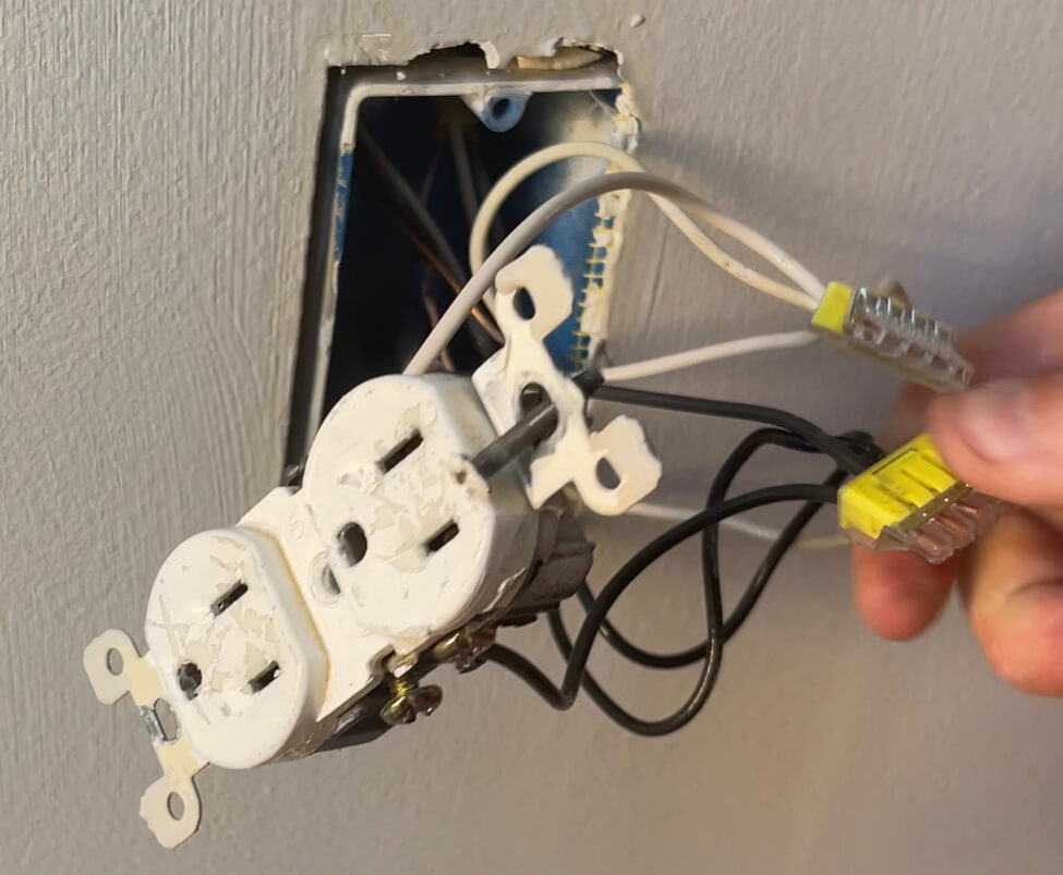 The existing outlet that now has four black wires, four white wires, and four ground wires all connected to each other respectively with wago connectors.